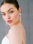Load image into Gallery viewer, Woman wearing elegant earrings against a neutral background
