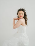 Load image into Gallery viewer, Woman wearing a white strapless dress against a plain background
