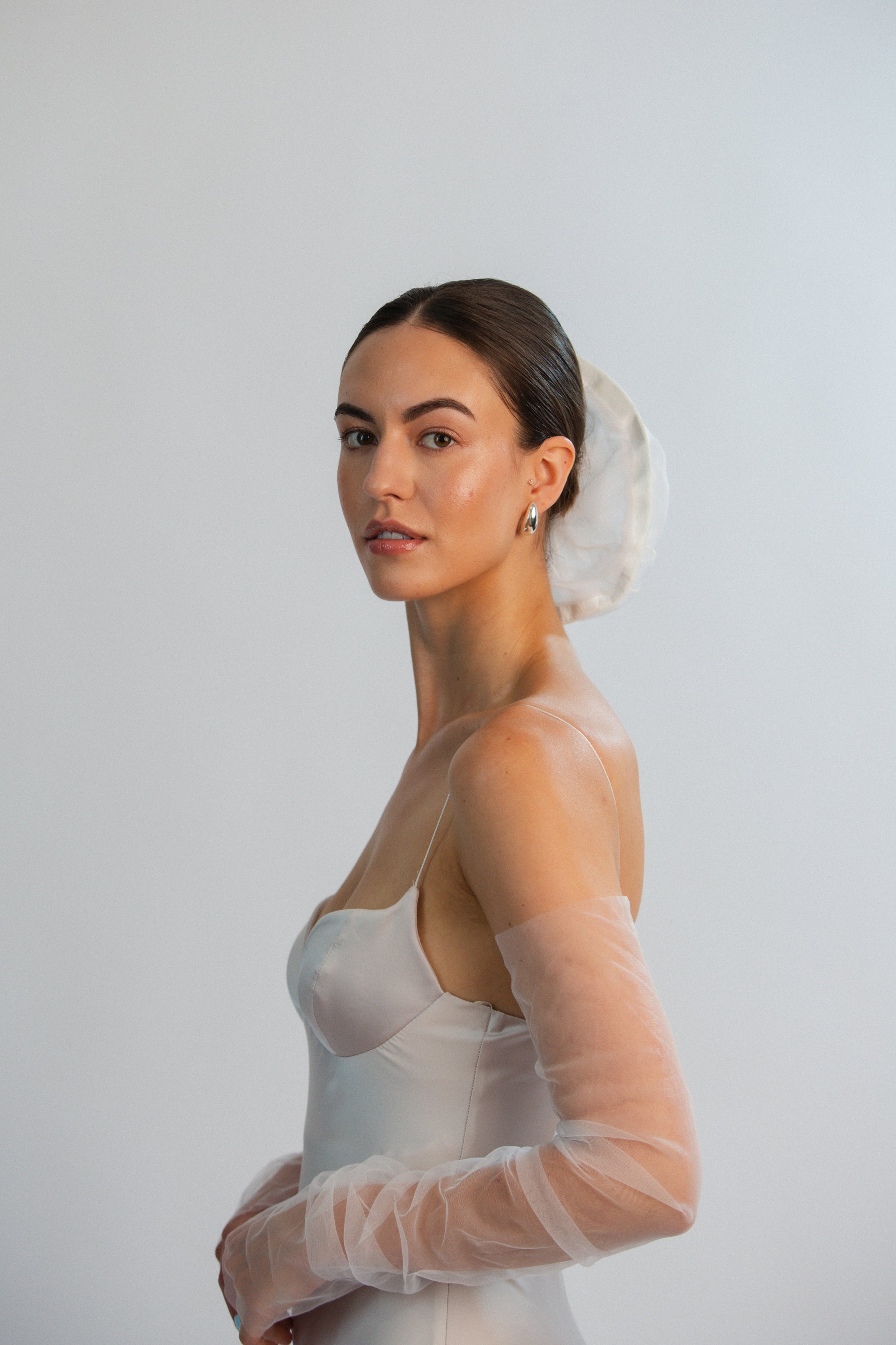 Woman wearing a sheer gloves with a plain background
