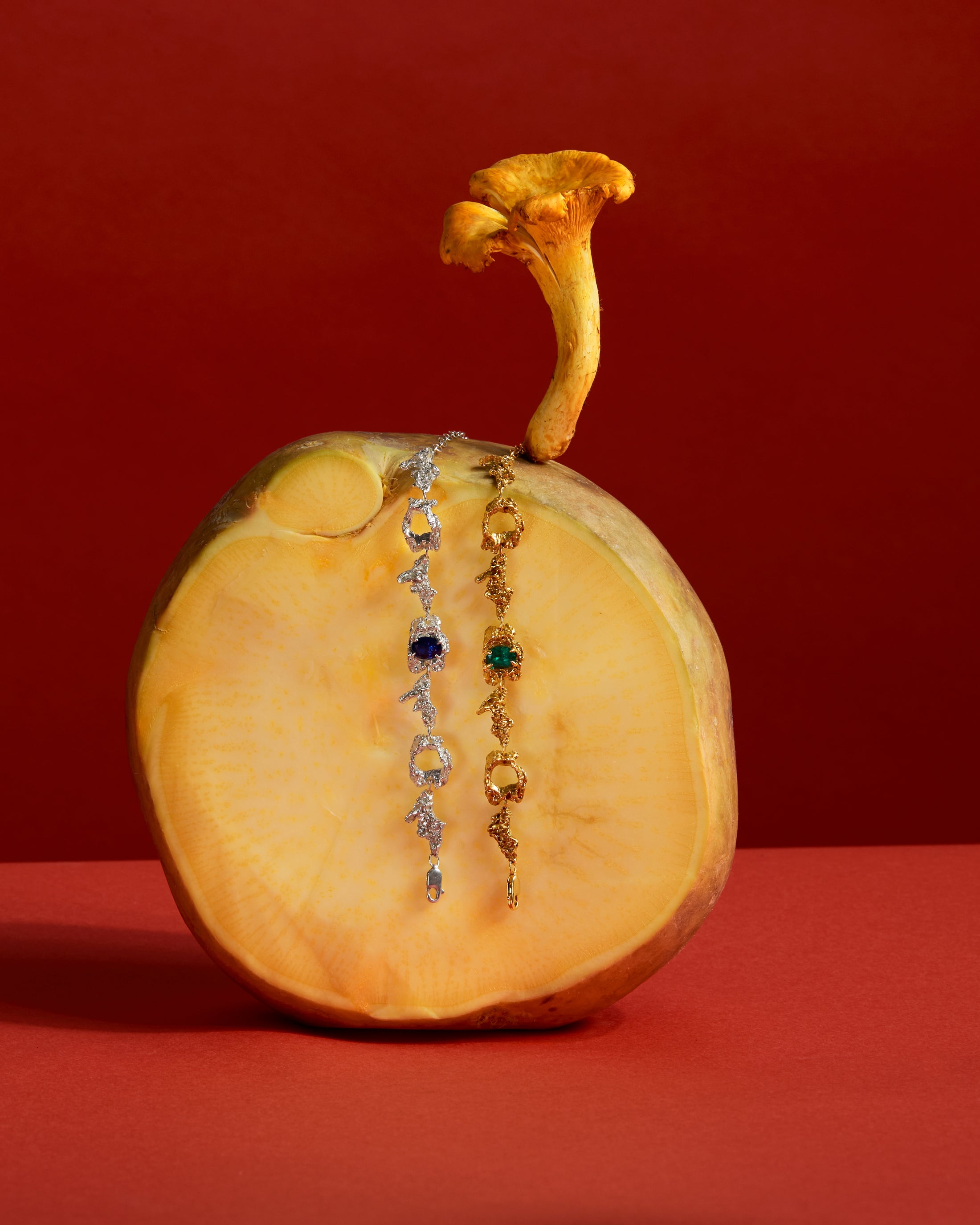 Two bracelets displayed on a halved pumpkin against a red background