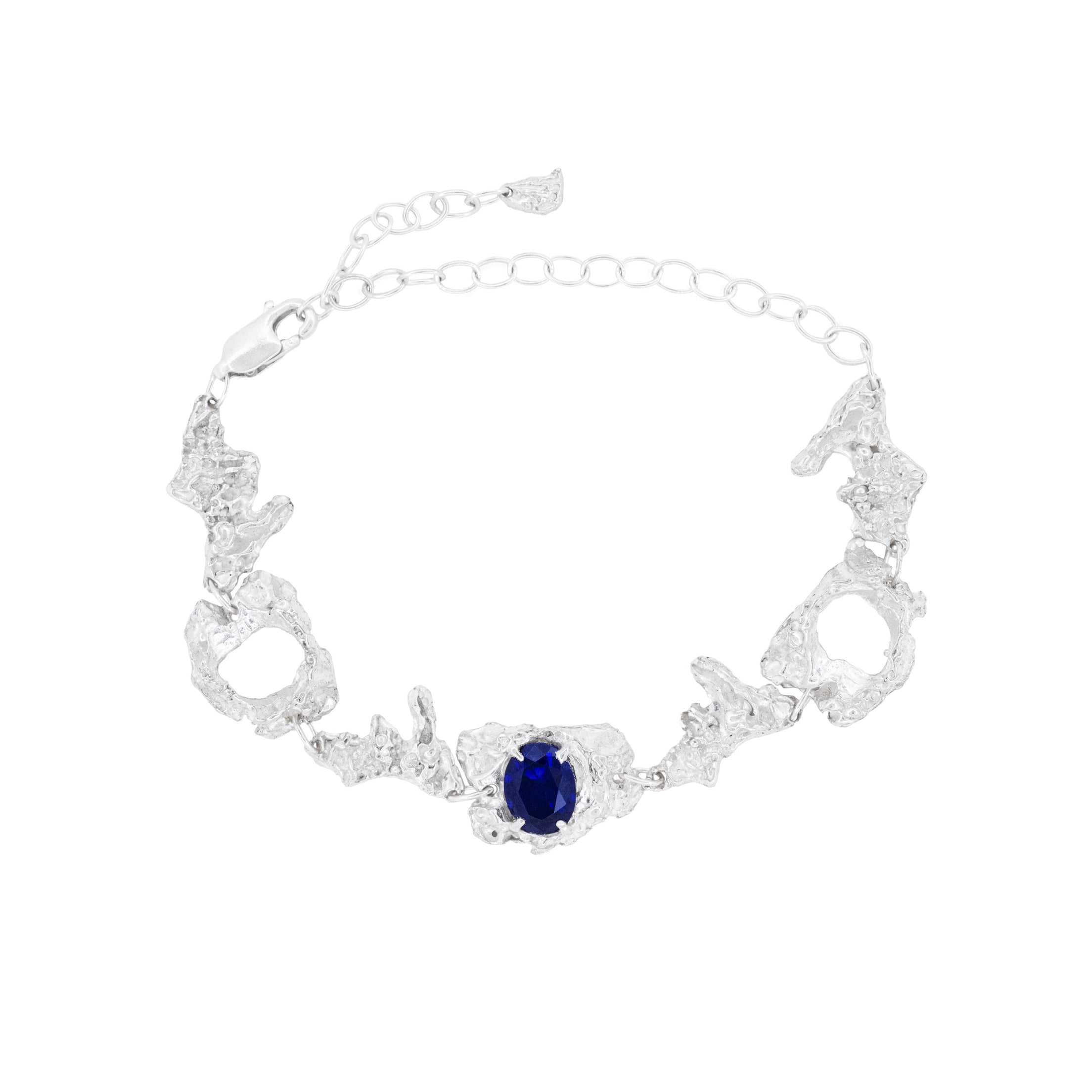 Silver bracelet with a sapphire on a white background