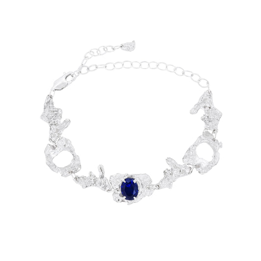 Silver bracelet with a sapphire on a white background
