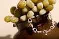 Load image into Gallery viewer, bracelet with a sapphire displayed on a bowl of grapes
