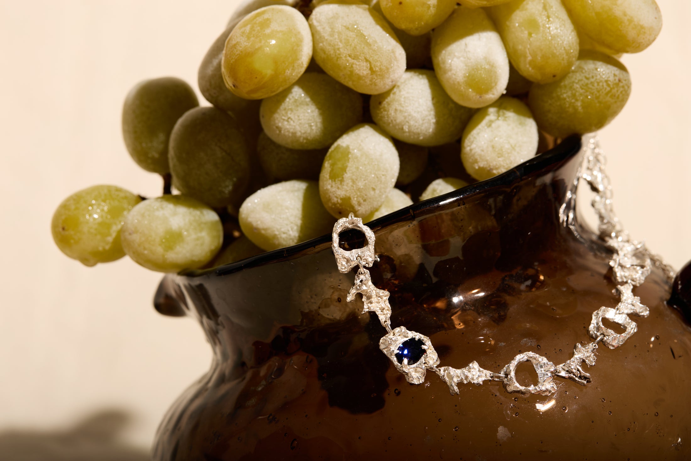 bracelet with a sapphire displayed on a bowl of grapes