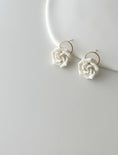 Load image into Gallery viewer, White rose-shaped earrings on a white background
