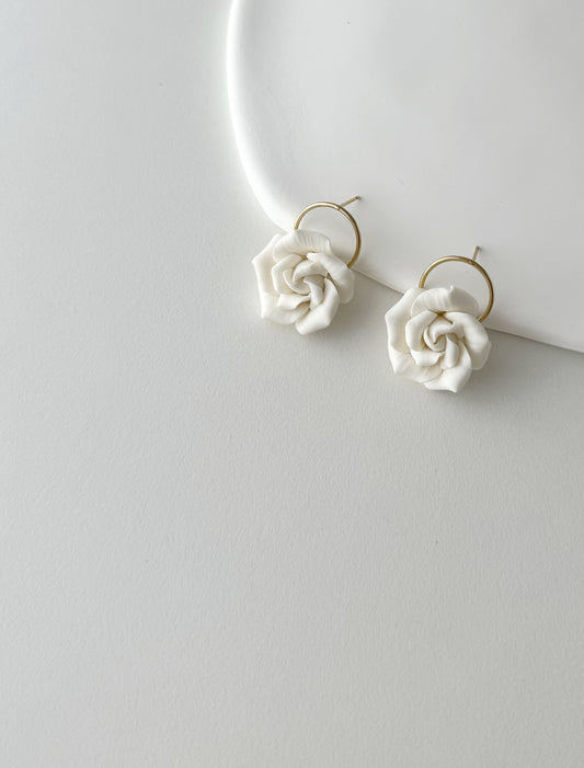 White rose-shaped earrings on a white background