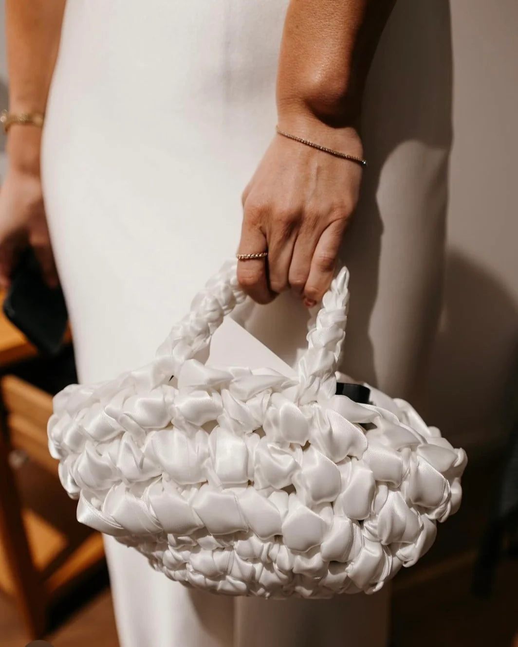 bride holding nest handbag in white