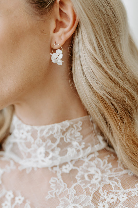 Close-up of a person wearing a delicate earring with a blurred background