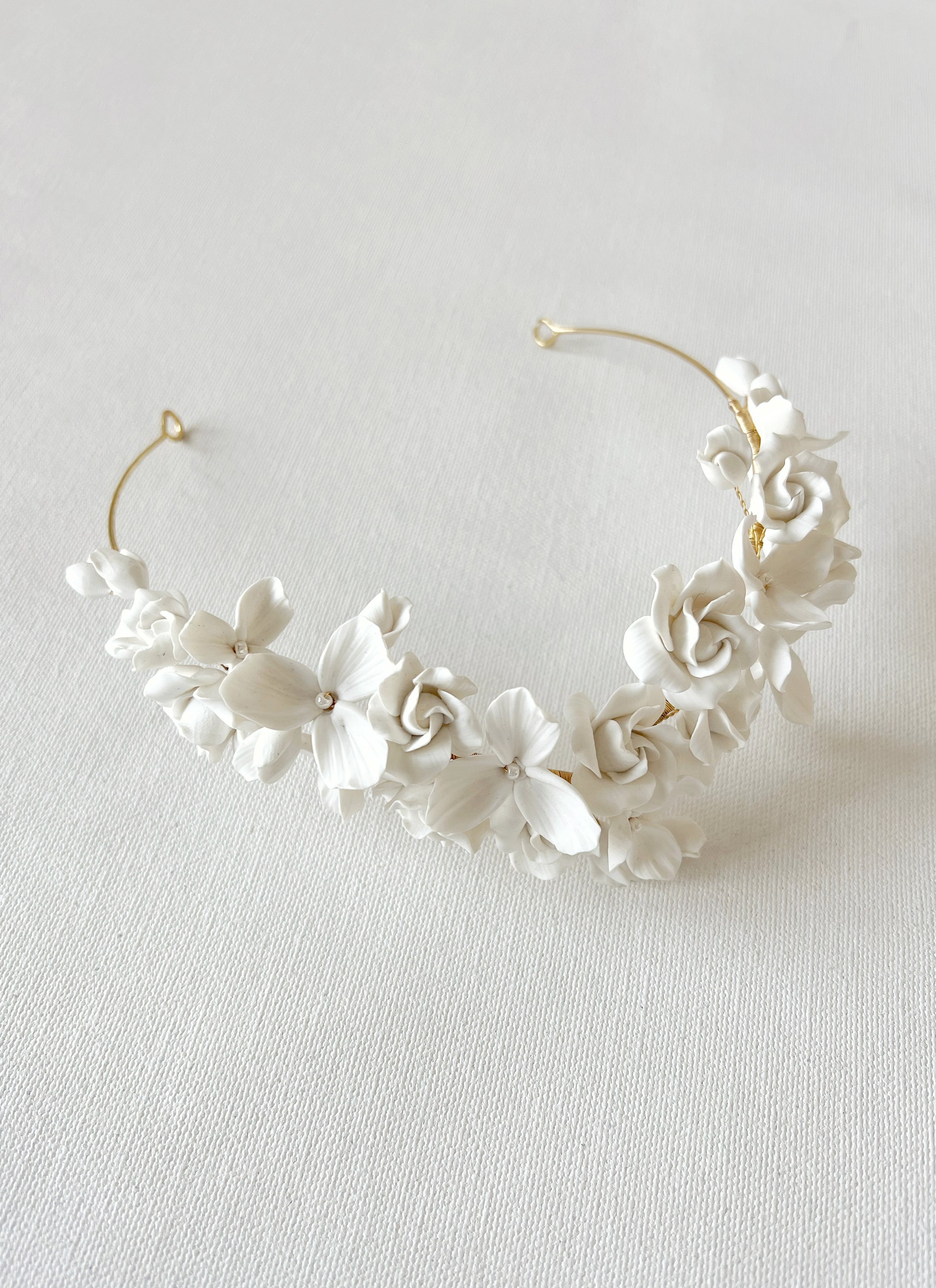 White floral headband on a light gray background