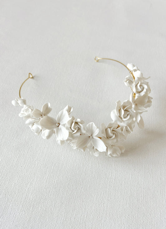 White floral headband on a light gray background