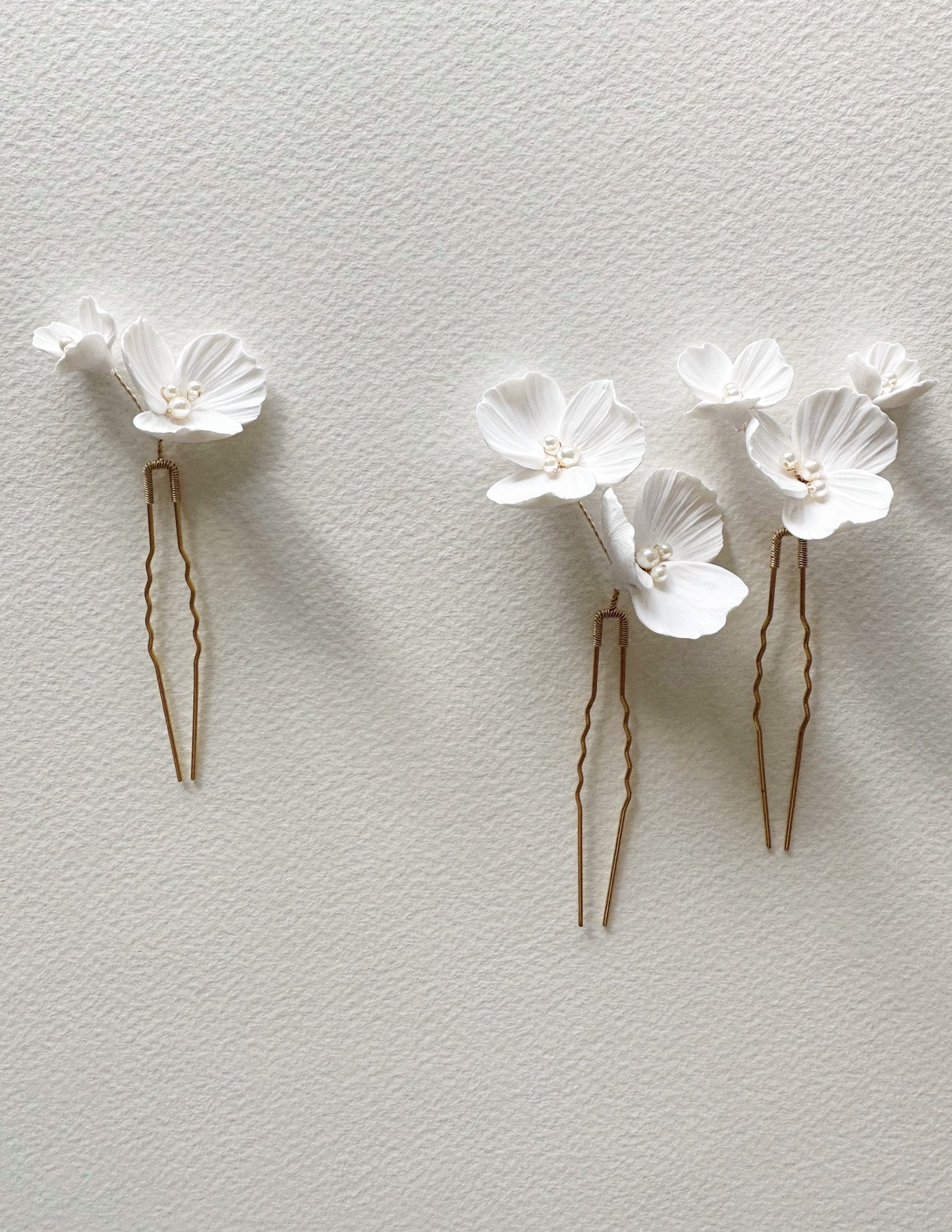 Two floral hair pins on a light gray background
