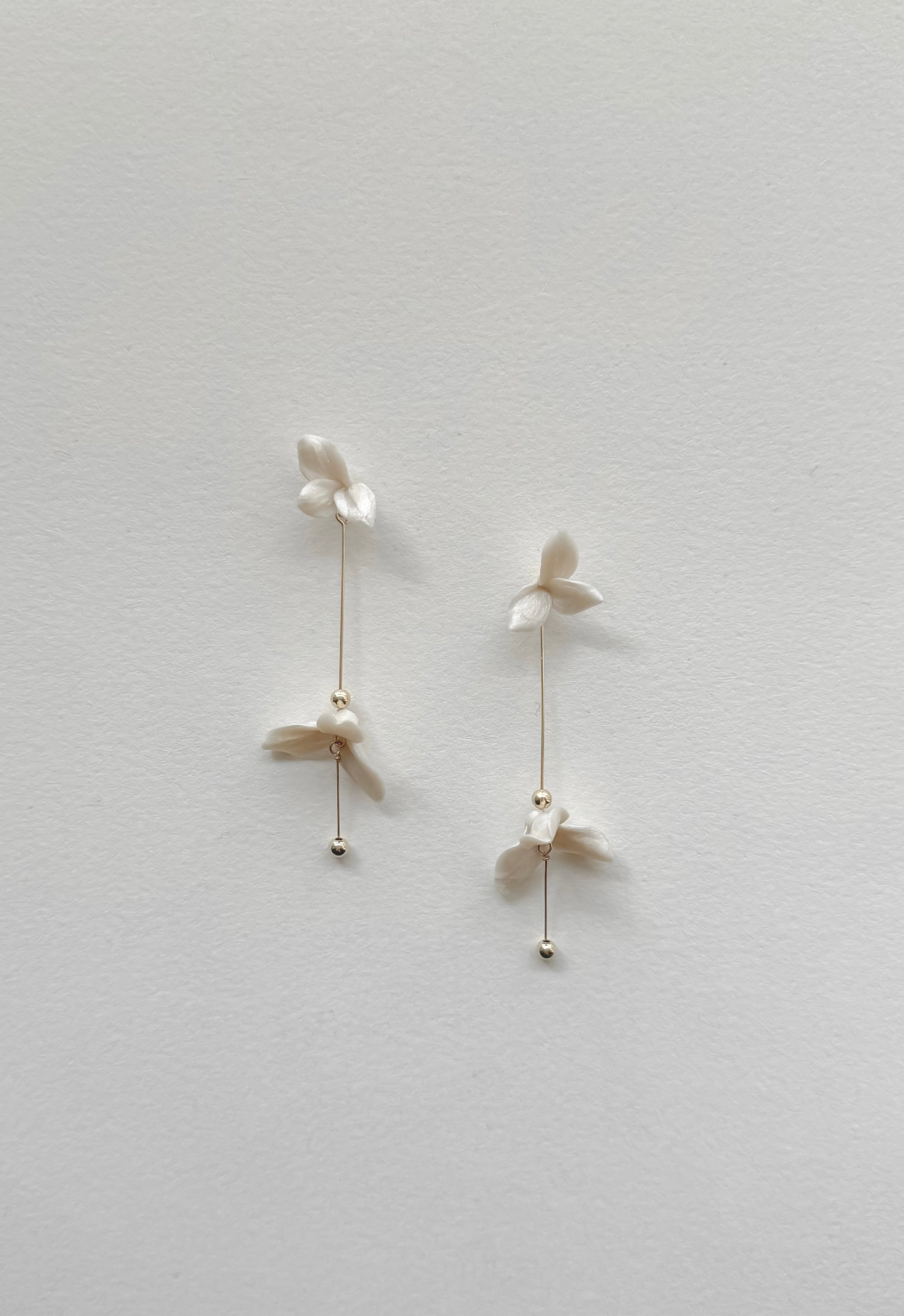Pair of delicate earrings on a light gray background