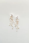 Load image into Gallery viewer, Pair of pearl earrings on a light gray background
