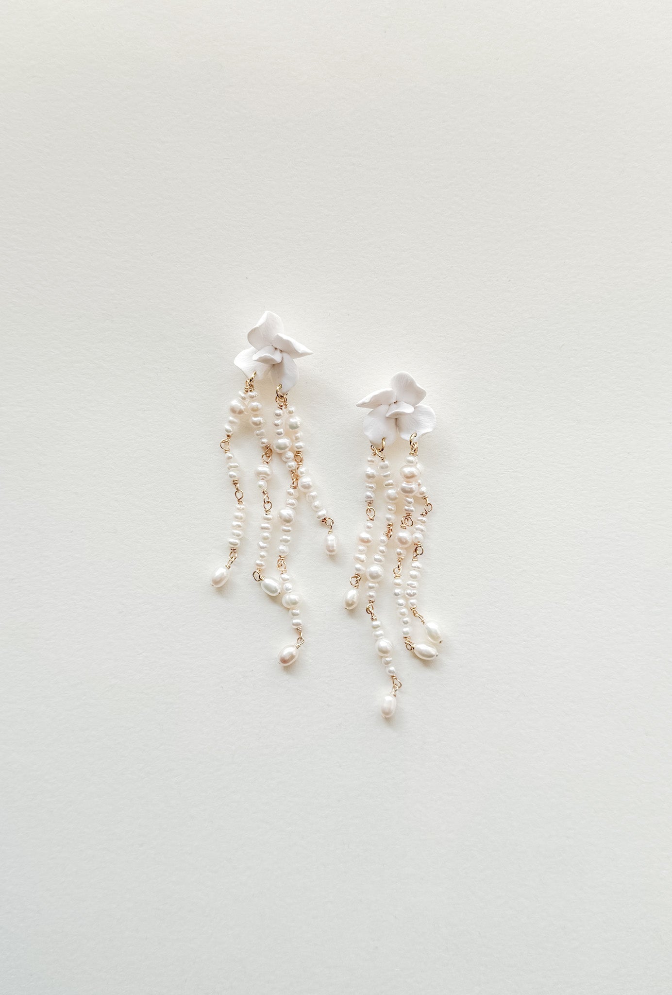 Pair of pearl earrings on a light gray background