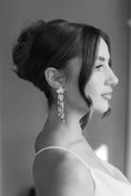 Load image into Gallery viewer, Black and white profile portrait of a woman wearing elegant earrings.
