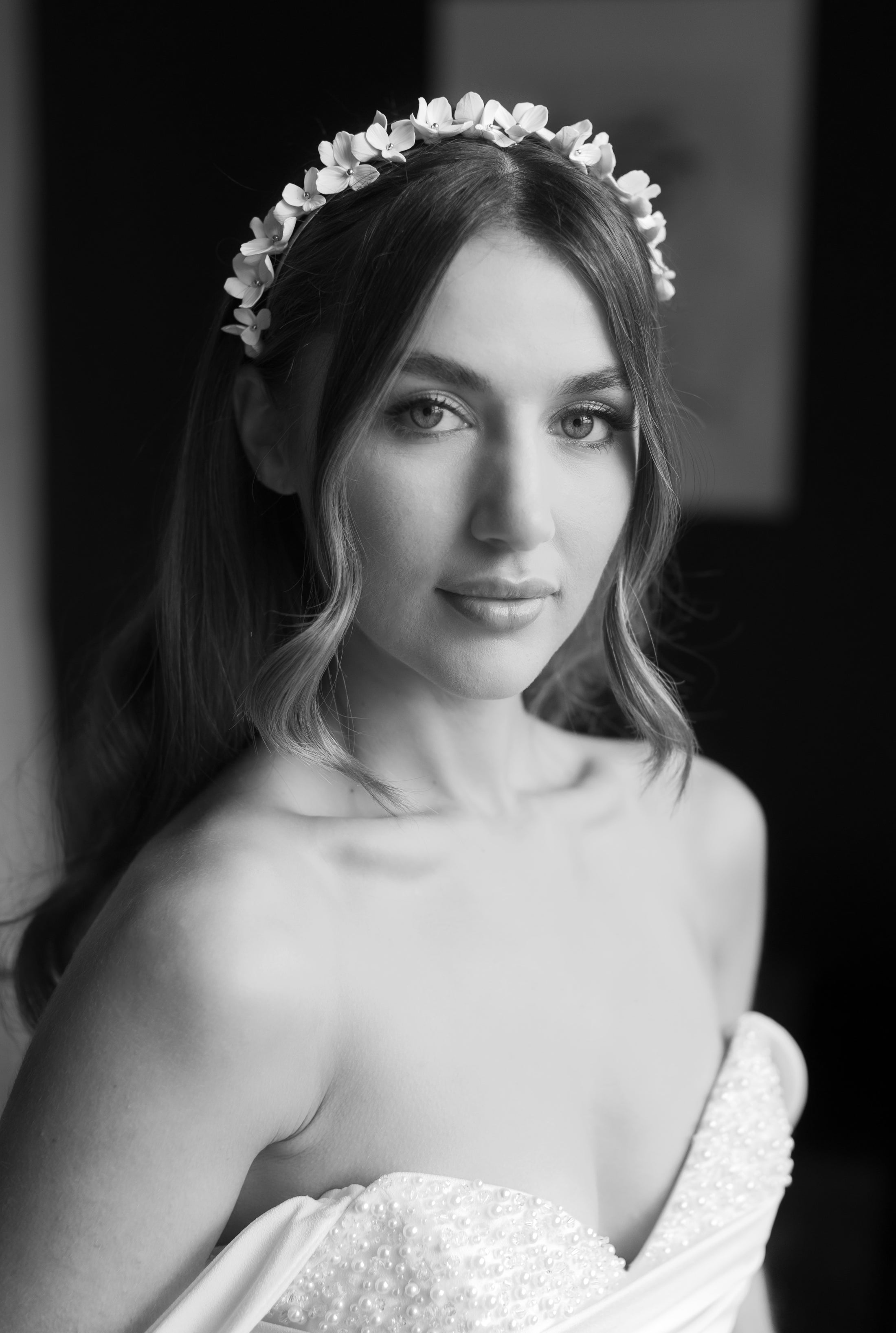 Black and white portrait of a bride wearing a floral headband.