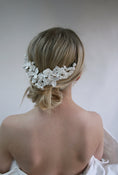 Load image into Gallery viewer, Woman with floral hairpiece against a plain background
