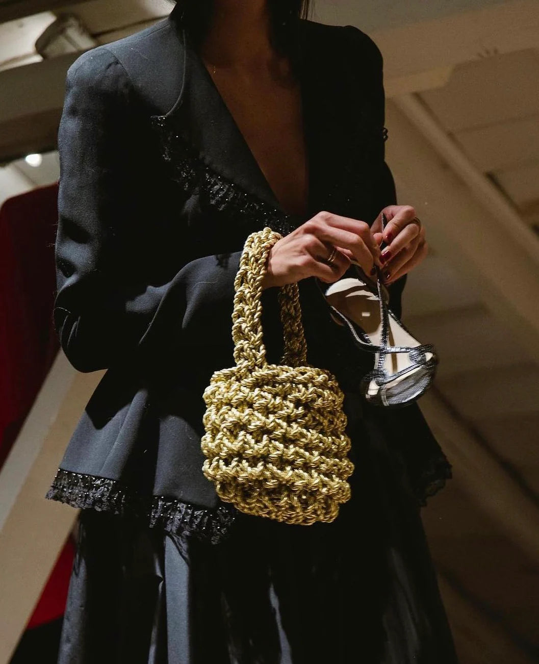 woman wearing hive metallic handbag in gold