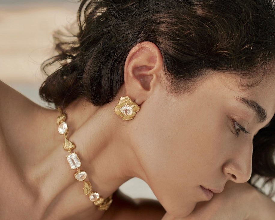 woman wearing gold earrings and necklace
