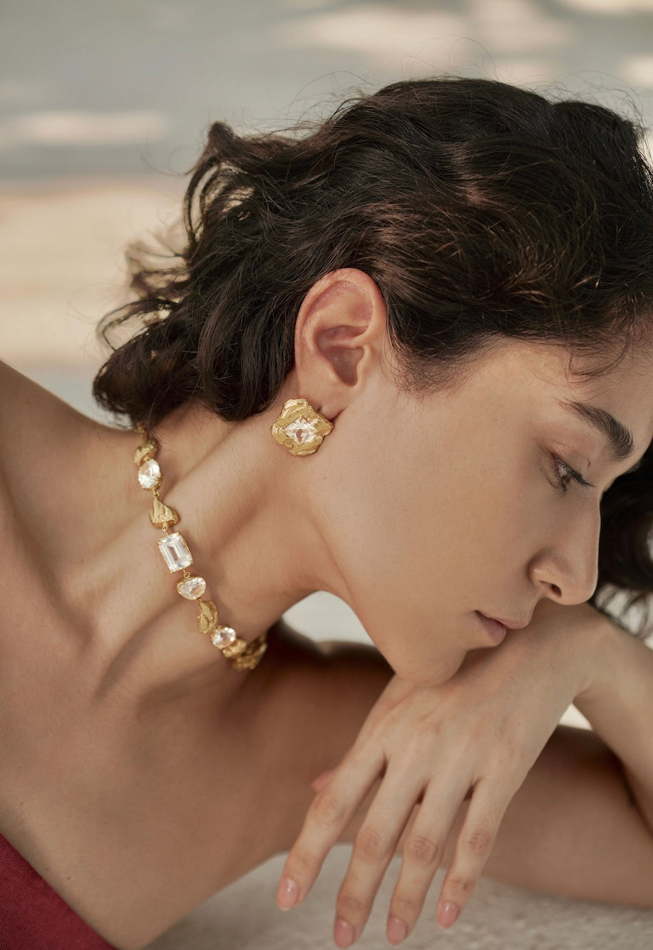woman wearing gold earrings and necklace
