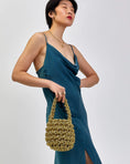 Load image into Gallery viewer, woman wearing hive metallic handbag in gold
