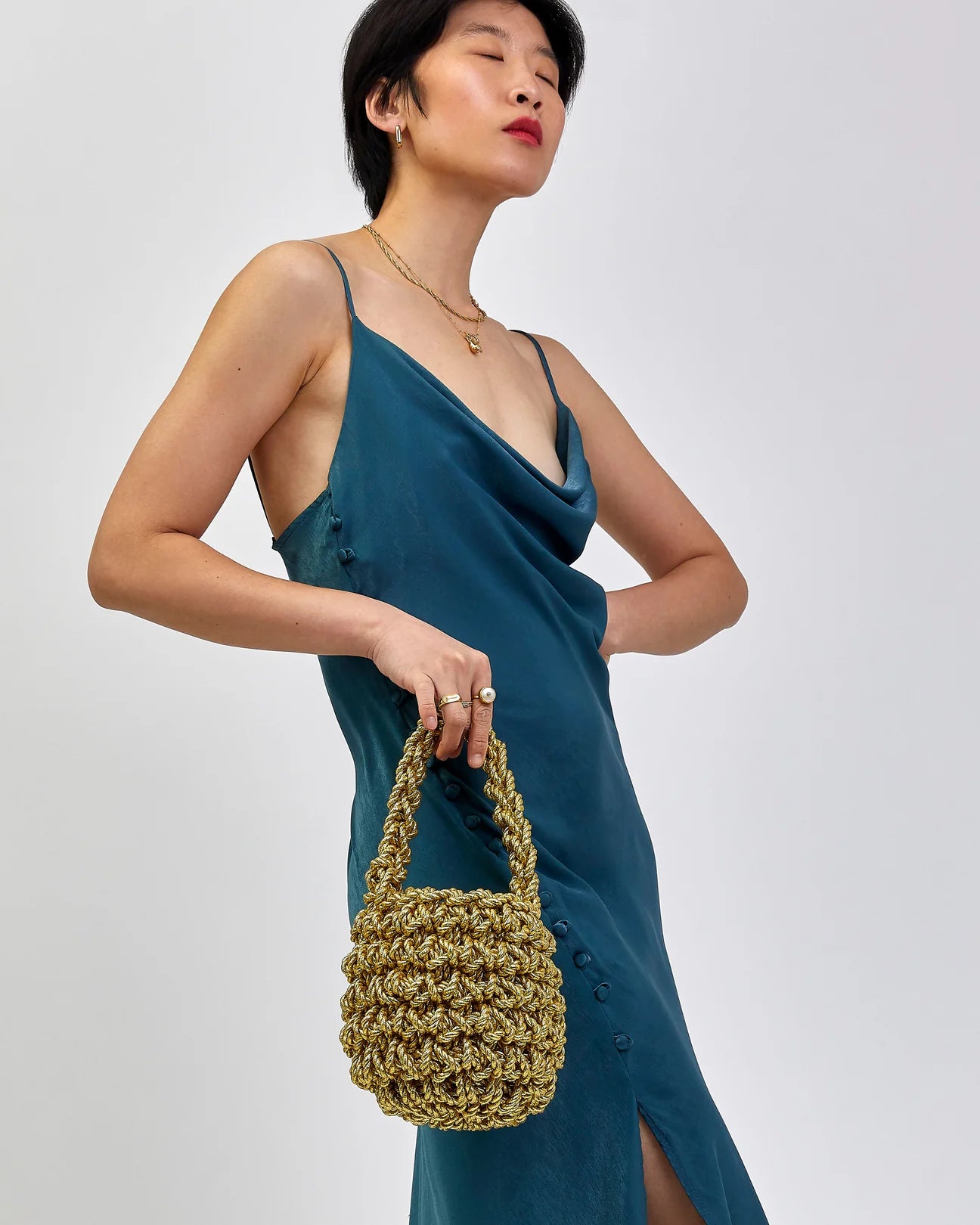 woman wearing hive metallic handbag in gold