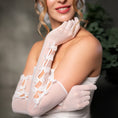 Load image into Gallery viewer, Woman wearing white gloves with lace details against a dark background

