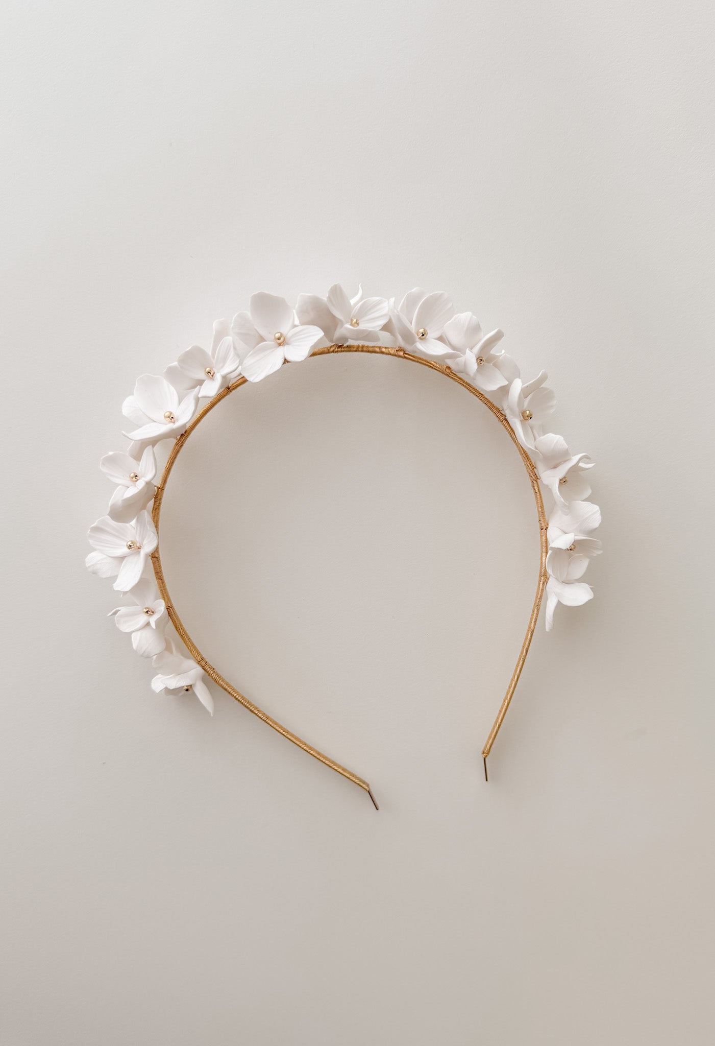 Floral headband with white flowers on a light gray background