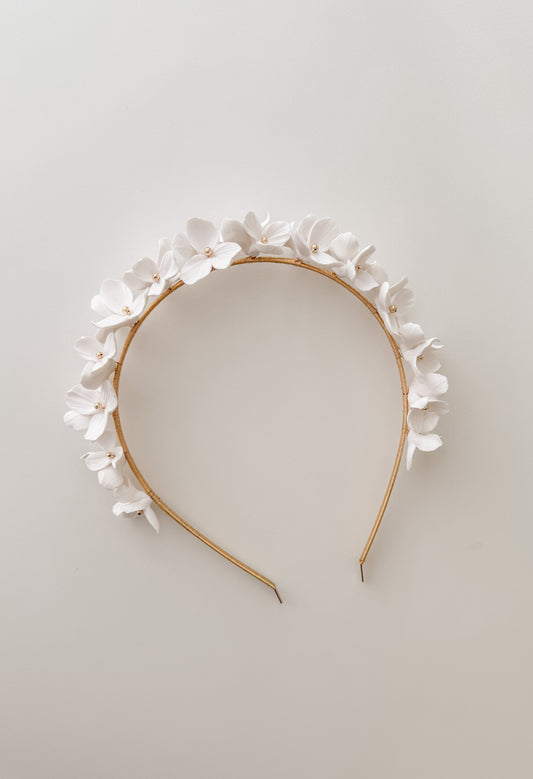 Floral headband with white flowers on a light gray background