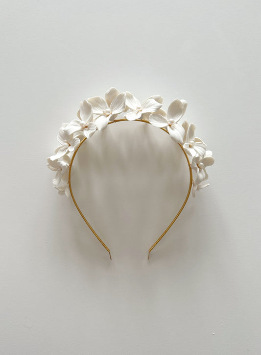 Floral headband with white flowers on a light gray background