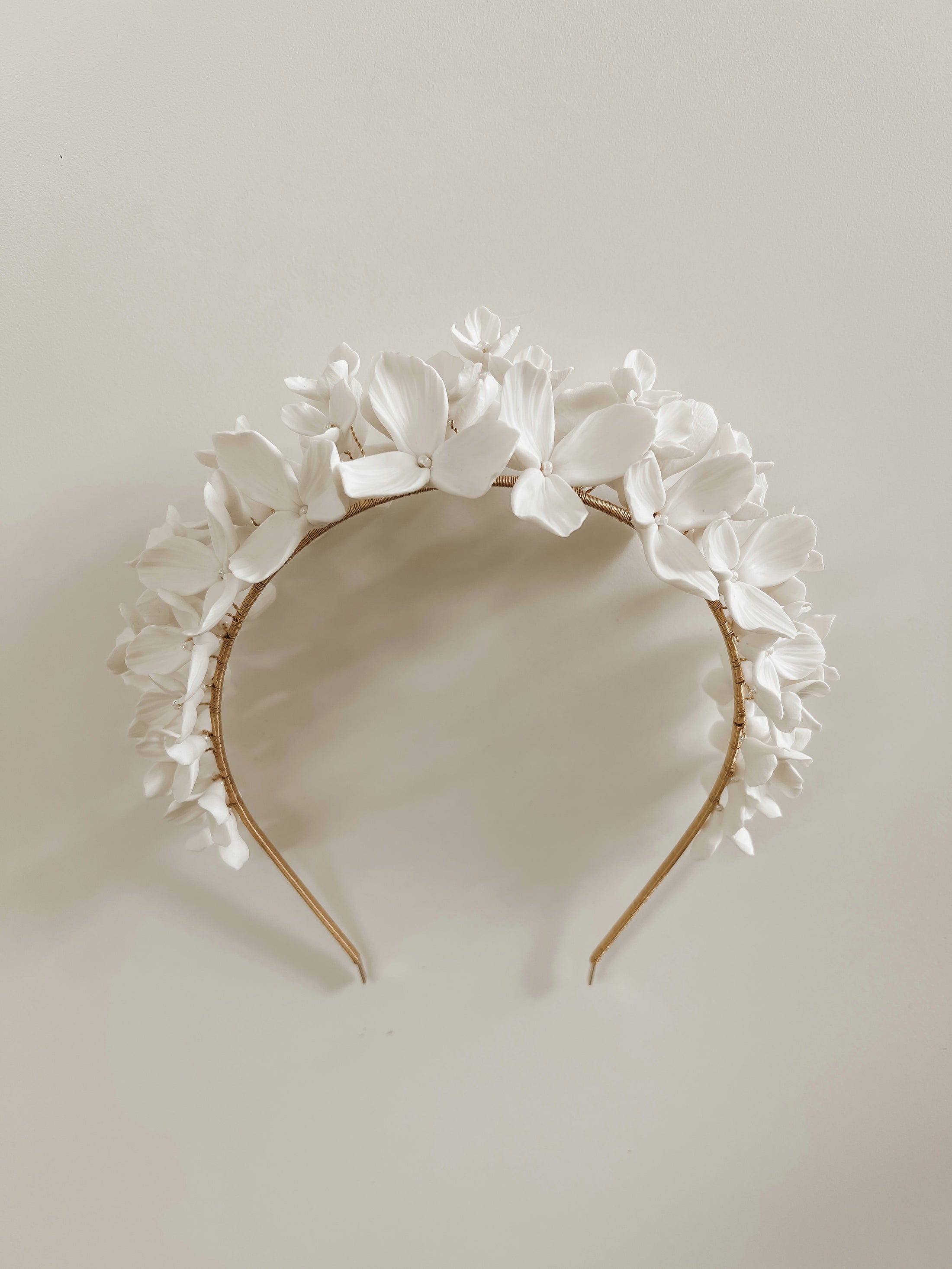 White floral headband on a light gray background