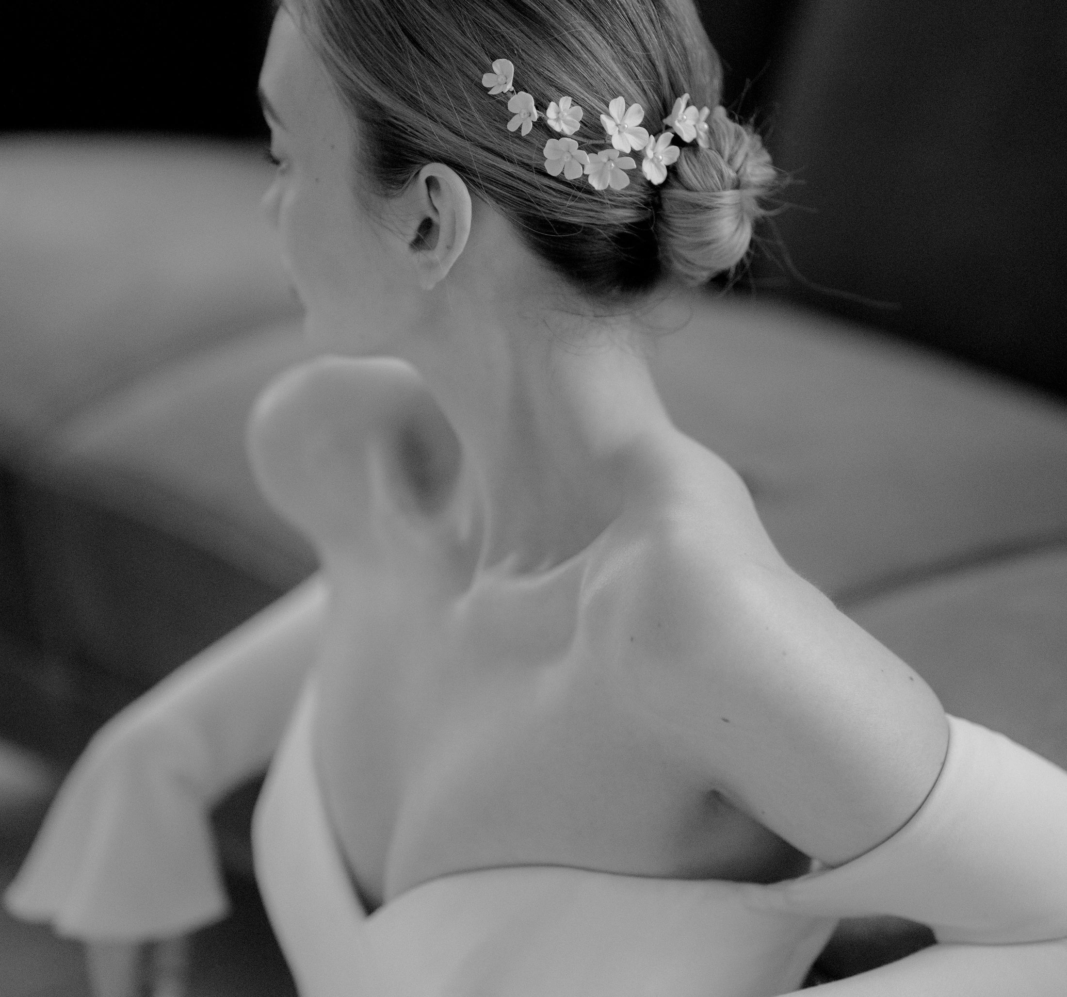 Black and white photo of a woman wearing a wedding dress with floral hairpiece.