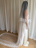 Load image into Gallery viewer, Bride wearing a white wedding dress with a lace veil against a white curtain background.
