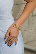 Load image into Gallery viewer, Close-up of a hand wearing gold bracelets and rings with a blurred background
