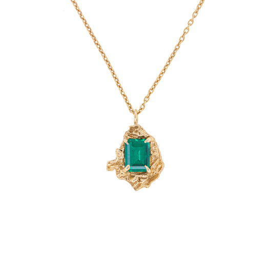 Gold necklace with an emerald pendant on a white background