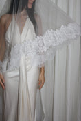 Load image into Gallery viewer, Bride wearing a white wedding dress with a lace veil against a white curtain background.
