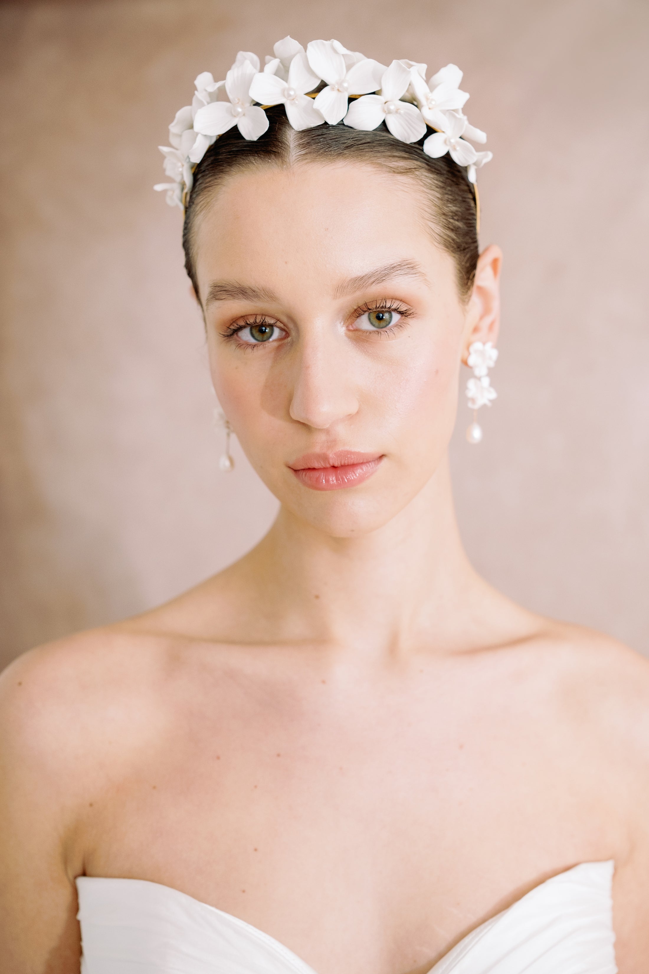 Woman wearing a floral headpiece against a neutral background