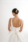 Load image into Gallery viewer, Woman wearing a white wedding dress with a plain background
