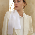 Load image into Gallery viewer, Woman wearing a light-colored blazer with a white hair ribbon against a beige wall.
