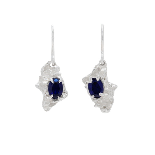 Silver earrings with sapphire on a white background