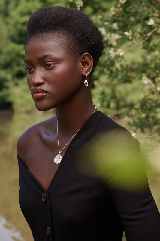 Woman wearing a black top with a blurred natural background