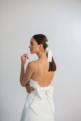 Load image into Gallery viewer, Woman in a white dress with a bow, standing against a plain background
