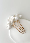 Load image into Gallery viewer, Gold hair comb with white flowers on a white plate

