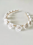 Load image into Gallery viewer, Floral headband with white flowers on a light gray background
