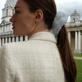 Load image into Gallery viewer, Woman with a hair bridal scrunchie and earring, facing away from the camera with a classical building in the background
