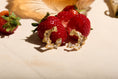Load image into Gallery viewer, Strawberries with gold leaf on a beige surface

