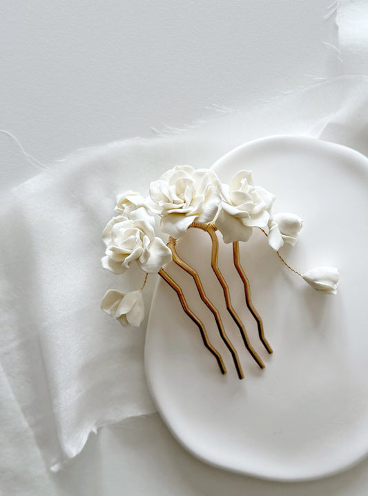 Decorative hair comb with white flowers on a white plate