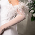 Load image into Gallery viewer, White feathered arm cover worn by a person, with a blurred background.
