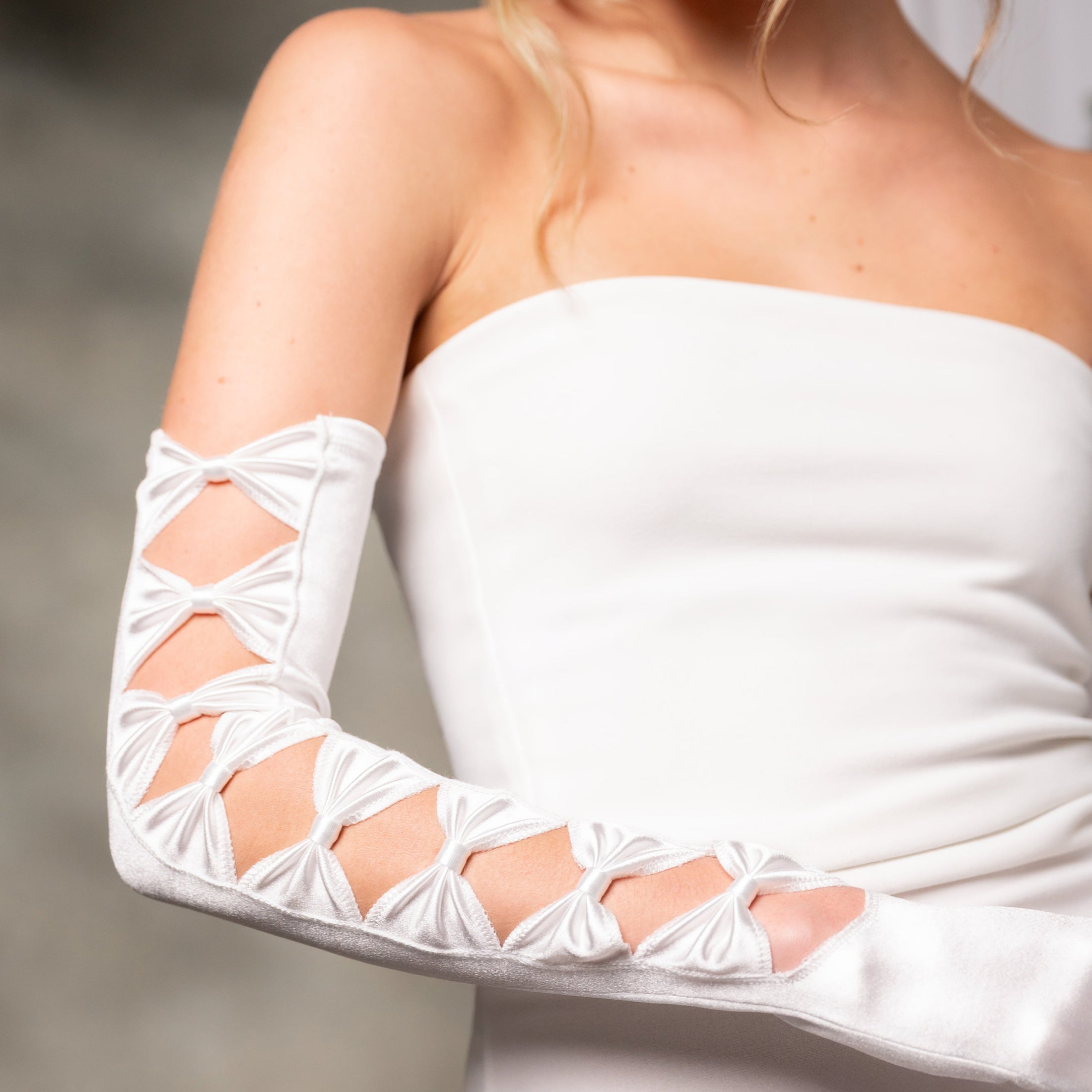 White strapless dress with opera gloves on a neutral background