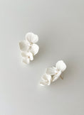 Load image into Gallery viewer, White orchid-shaped earrings on a light gray background
